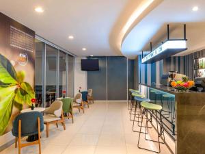 a restaurant with a bar with chairs and tables at ibis Bangkok Sathorn in Bangkok
