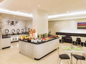 a restaurant with a counter with food on it at ibis Bangkok Sathorn in Bangkok