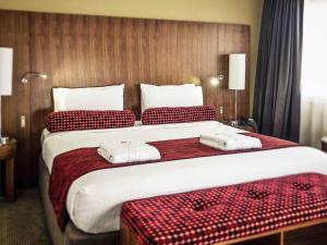 a hotel room with a large bed with towels on it at Mercure Sydney Liverpool in Liverpool +110 photos