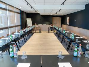 a large room with tables and chairs with bottles on them at ibis Loriol Le Pouzin in Le Pouzin