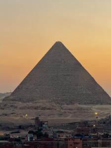 a view of the pyramid of giza at sunset at Continental Pyramids INN & Roof Top in Cairo +97 photos