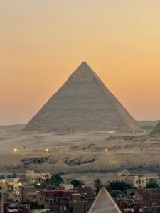 a view of the pyramids of giza at sunset at Continental Pyramids INN & Roof Top in Cairo