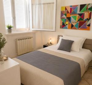 a bedroom with a bed with a painting on the wall at La Villetta in Scheggino