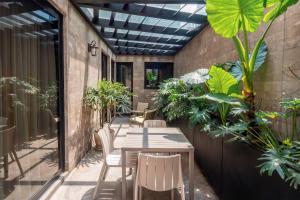 a patio with a table and chairs and plants at Frida by Viadora in Mexico City