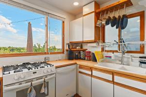 a kitchen with a stove and a sink and a window at Restored Adobe Casita Big Views Walk to Plaza in Santa Fe