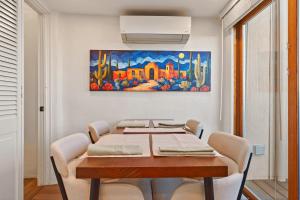 a dining room table with chairs and a painting on the wall at Restored Adobe Casita Big Views Walk to Plaza in Santa Fe