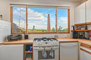 a kitchen with a stove and a large window at Restored Adobe Casita Big Views Walk to Plaza in Santa Fe