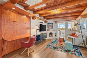 a living room with wooden ceilings and a red chair at Restored Adobe Casita Big Views Walk to Plaza in Santa Fe +26 photos