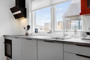 a white kitchen with a sink and a window at 9954-Hvide-Sande-Langsand-214 in Hvide Sande +37 photos