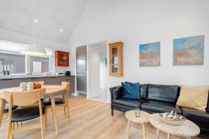 a living room with a black couch and a table at 9954-Hvide-Sande-Langsand-214 in Hvide Sande
