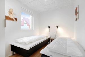 a bedroom with two beds and a window at 9954-Hvide-Sande-Langsand-214 in Hvide Sande