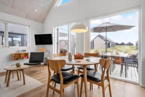 a dining room with a table with chairs and an umbrella at 9954-Hvide-Sande-Langsand-214 in Hvide Sande