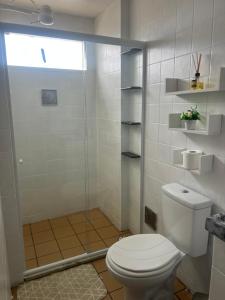 a bathroom with a toilet and a glass shower at Apartamento Beira Mar in Maceió