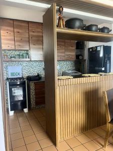 a kitchen with wooden cabinets and a stove at Apartamento Beira Mar in Maceió