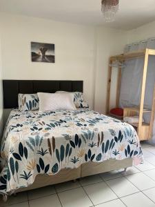 a bedroom with a bed with a blue and white comforter at Apartamento Beira Mar in Maceió