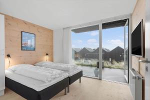 a bedroom with a bed and a large window at 7726-Hvide-Sande-Slusen-26 in Hvide Sande