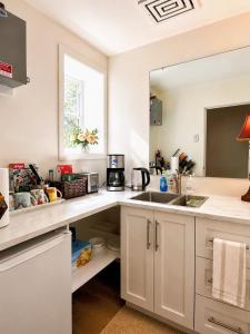 a kitchen with white cabinets and a sink at Oceanfront Escape with Private Bath and Beach Access in Gibsons