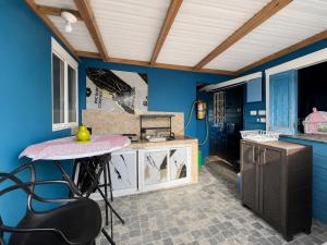 a kitchen with blue walls and a table and chairs at Miss Titi's Native Lodge in San Andrés