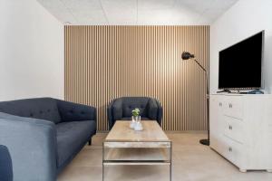 a living room with a couch and a tv and a table at 782-Hvide-Sande-Norregade-2-nr-25 in Hvide Sande