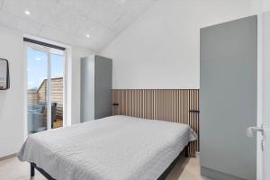 a bedroom with a white bed and a window at 782-Hvide-Sande-Norregade-2-nr-25 in Hvide Sande
