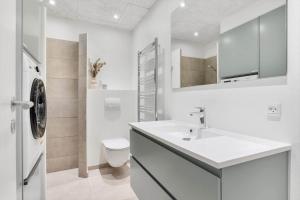 a white bathroom with a sink and a toilet at 782-Hvide-Sande-Norregade-2-nr-25 in Hvide Sande +27 photos