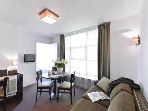 a living room with a couch and a table at Aparthotel Adagio Access Toulouse St Cyprien in Toulouse