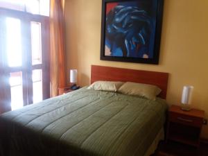 1 dormitorio con 1 cama y una pintura en la pared en Miraflores, en Lima