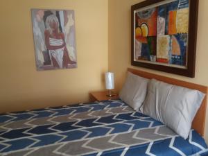 - une chambre avec un lit et une peinture murale dans l'établissement Miraflores, à Lima
