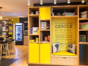 a yellow book shelf with a sign in a room at Aparthotel Adagio Access Bruxelles Europe Aparthotel in Brussels +18 photos