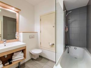 a bathroom with a toilet and a sink and a shower at Aparthotel Adagio Access Bruxelles Europe Aparthotel in Brussels