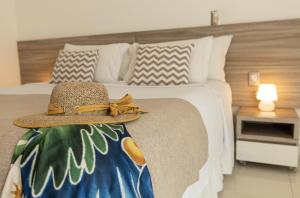a hat sitting on a bed in a bedroom at SERHS Beach Hotel in Natal +79 photos