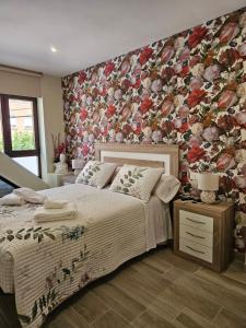 a bedroom with a bed with a floral wall at la herencia B VUT 1693 in Ponferrada