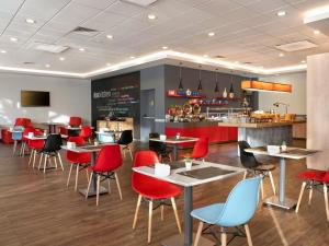 a restaurant with red chairs and tables and a counter at ibis Ankara Airport Hotel in Ankara