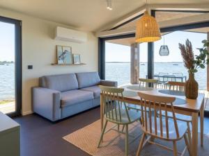a living room with a blue couch and a table and chairs at Guesthouse Seeblick in Breitenbrunn