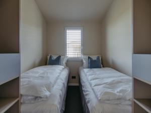 two beds in a small room with a window at Guesthouse Seeblick in Breitenbrunn