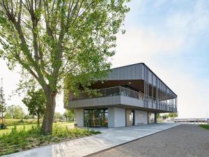 a large building with a tree in front of it at Guesthouse Seeblick in Breitenbrunn