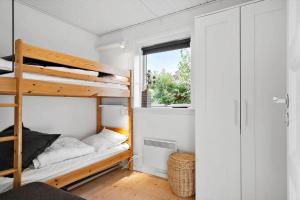 a bedroom with two bunk beds and a window at 7032-Bogo-Kvaernen-32 in Gammelby