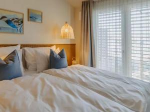 a white bed in a bedroom with a window at Guesthouse Leithagebirge in Breitenbrunn