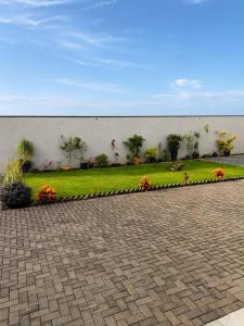 a garden with flowers in front of a wall at Village Conti Ideal para casal com Ar C01 in Campinas
