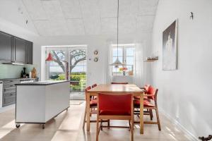 a kitchen with a dining room table and chairs at 8119-Praesto-Over-Lyngen-19 in Præstø