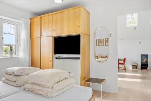 a bedroom with a bed with pillows and a mirror at 8119-Praesto-Over-Lyngen-19 in Præstø
