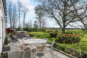 a patio with a table and chairs in a garden at 8119-Praesto-Over-Lyngen-19 in Præstø