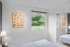 a white room with a bed and a window at 1111-Stege-Ulvshalevej-111 in Stege