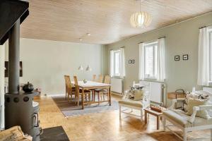 a living room with a fireplace and a table and chairs at 4302-Stege-Nordfeldvej-48-B in Stege