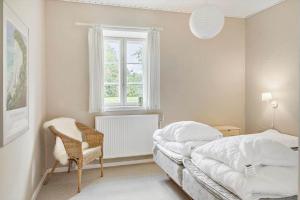 a bedroom with a bed and a chair and a window at 4302-Stege-Nordfeldvej-48-B in Stege