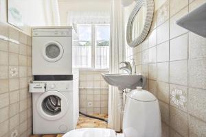 a bathroom with a washing machine and a sink at 4302-Stege-Nordfeldvej-48-B in Stege +12 photos