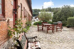 a patio with a table and chairs and a table and benches at 4302-Stege-Nordfeldvej-48-B in Stege
