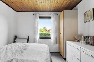 a bedroom with a bed and a window at 7041-Bogo-By-Tarnbakken-21 in Bogø By