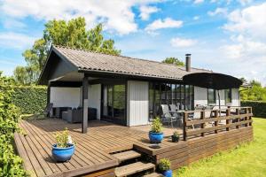 a house with a deck with an umbrella at 7041-Bogo-By-Tarnbakken-21 in Bogø By