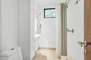 a white bathroom with a toilet and a sink at 2007-Stege-Aedelgranen-3 in Stege +13 photos